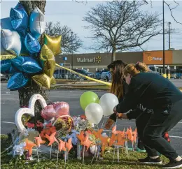  ?? KENNY HOLSTON/THE NEW YORK TIMES ?? People mourn Thursday at the scene of a mass shooting at a Walmart in Virginia.