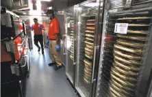  ?? Michael Macor / The Chronicle ?? Zume employees Gustavo Vega (left) and Skylar Morris prepare pizzas that will be baked in the firm’s delivery trucks.