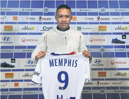  ??  ?? Memphis Depay poses with his Lyon jersey.