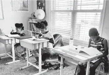  ?? DALAINE BRADLEY ?? From left, Drew Waller, 7, Zion Waller, 10, and Ahmad Waller, 11, study during home-schooling in Raleigh, N.C.