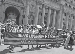  ?? PHOTOS BY KATHY WILLENS/ASSOCIATED PRESS ?? Protesters stretch out a banner at the beginning of a queer liberation march for Black Lives Matter and against police brutality Sunday in New York. The march commemorat­ed the 50th anniversar­y of Pride after New York’s normally massive gay Pride march was canceled due to concerns over the spread of the coronaviru­s.