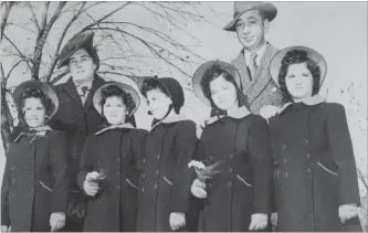  ?? THE CANADIAN PRESS FILE PHOTO ?? Elzire and Olivia Dionne stand with their world-famous quintuplet­s, Cecile, Yvonne, Marie, Emilie and Annette. . Cecile and Annette are the two surviving sisters.