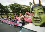  ?? AARON FAVILA/AP ?? Human rights groups march past an effigy of Philippine President Ferdinand Marcos Jr. on Wednesday in Manila as they mark the 50th anniversar­y of martial law imposed by his father, dictator Ferdinand Marcos. Survivors of torture and other atrocities want justice and an apology from the younger Marcos, who was giving a speech at the U.N. General Assembly.