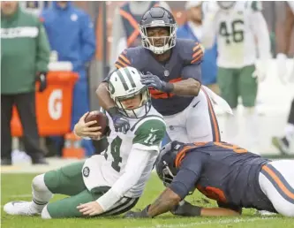  ?? GETTY IMAGES ?? The Jets’ Sam Darnold is brought down by Roy Robertson-Harris (right) and Sherrick McManis.
