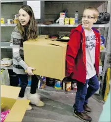  ??  ?? Siblings Jaycie, left, and Ryan Dwarzak lend a hand at the West Island Mission.