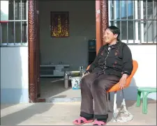  ?? HOU LIQIANG / CHINA DAILY ?? Jinhuo Buwei sits outside her new home in Binchuan, Yunnan province.