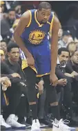  ??  ?? Golden State Warriors forward Kevin Durant holds his knee after being injured against the Washington Wizards in the first quarter at Verizon Centre — USA TODAY Sports photo