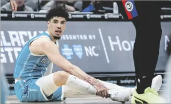  ?? AP PHOTO/JACOB KUPFERMAN ?? Charlotte Hornets guard LaMelo Ball holds his ankle after being shaken up on a play during the second half of an NBA basketball game against the Detroit Pistons in Charlotte, N.C., on Monday.