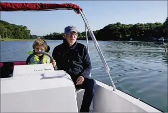  ??  ?? Léon, bientôt sept ans, prend la barre sous l’oeil de son grand-père, Jean-Michel Viant, qui possède plusieurs tours du monde à la voile à son actif.