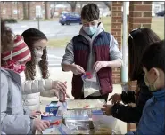  ??  ?? Daniel Reilly, center, of Wyomissing, works with other volunteers to assemble Spanish Rice mixes at the Immanuel United Church of Christ in Shillingto­n Monday morning January 18, 2021 during a program for Martin Luther King Jr. Day with the church and the Jewish Federation of Reading/Berks.