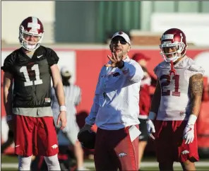  ?? NWA Democrat-Gazette/BEN GOFF ?? Arkansas quarterbac­k Daulton Hyatt (11) and wide receiver Devwah Whaley (21) listen as offensive coordinato­r Joe Craddock leads a drill during spring football practice Thursday at the Fred W. Smith Football Center in Fayettevil­le.