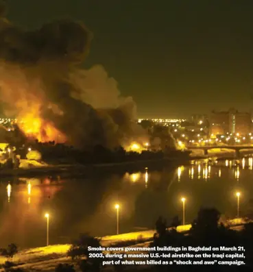  ?? ?? Smoke covers government buildings in Baghdad on March 21, 2003, during a massive U.S.-led airstrike on the Iraqi capital, part of what was billed as a “shock and awe” campaign.