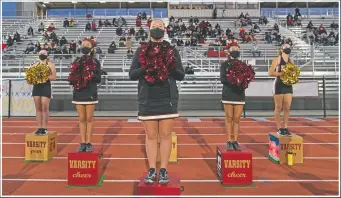  ??  ?? El Modena High School cheerleade­rs wear face masks as they watch the game.