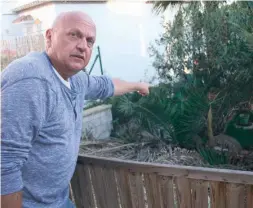  ?? Foto: Lena Kuder ?? Bernd Hogen deutet auf die mit einer Mauer abgetrennt­e Grünzone. Dort liegt auch der besagte Kanaldecke­l.