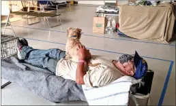  ?? Rachel Scheier / KHN /TNS ?? Bart Pettijohn rests on his cot with his dog, Clumsy, in an evacuation center at the Petaluma Veterans Memorial Building on Sept. 30. Volunteer health care workers and a veterinari­an were among those who checked up on dozens of seniors and pets forced out of their homes during the biggest wildfire season in California history.