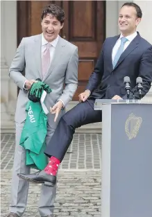  ?? NIALL CARSON, AP ?? Prime Minister Justin Trudeau is thrilled as Leo Varadkar, his Irish counterpar­t, shows off his Canada-themed socks during a news conference Tuesday in Dublin. The red socks were emblazoned with maple leaves and cartoonish Mounties.