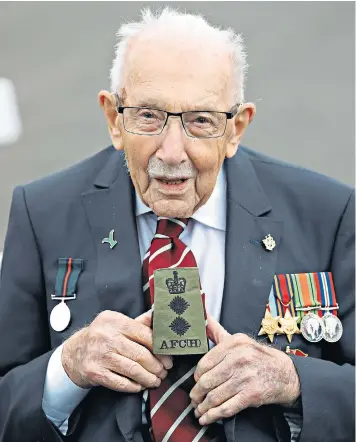  ??  ?? Captain Sir Tom Moore shows his honorary colonel badge during his visit to the Army Foundation College in Harrogate