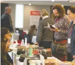  ?? BRANDON HARDER ?? People browse a table with books for sale during the Saskatchew­an Writers’ Guild weekend conference held at the Travelodge hotel.