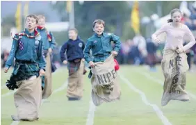  ?? CHRIS JACKSON/Getty Images ?? Children participat­e in the sack race at the annual Braemer Highland Games in Braemar, Scotland, in September. A British educator says too many organized activities for kids could
lead to problems later in life.