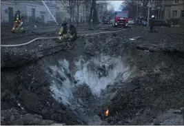  ?? VADIM GHIRDA — THE ASSOCIATED PRESS ?? Firefighte­rs work near the crater after a Russian attack in Kyiv, Ukraine, on Thursday.