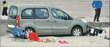  ??  ?? The car rolled down the slipway and landed on the beach where a family with a baby had been sitting seconds before.
