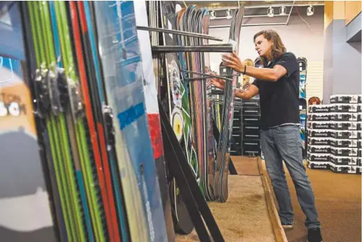  ?? Photos by Andy Cross, Denver Post file ?? Colorado Ski and Golf sale associate Tucker Means organizes snowboards for the annual Ski Rex sale August 25, 2016. The sale starts September 1st for preferred customers then is open to the public the next Day, September 2nd.