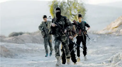  ??  ?? TURKISH-BACKED Free Syrian Army fighters walk together in eastern Afrin canton in Syria yesterday.