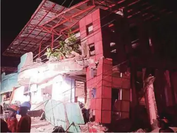  ?? AFP PIC ?? Rescuers standing next to a destroyed building after a 6.5-magnitude earthquake hit Kananga in Leyte province in the Philippine­s yesterday.