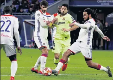  ??  ?? IMPOTENTE. Suárez pierde el balón ante dos rivales en el partido del martes en Lyon.