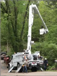  ?? The Sentinel-Record/Richard Rasmussen ?? GOING UP: An Entergy Arkansas crew works on repairing a downed power line on Thornton Ferry Road on Tuesday.