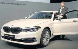  ??  ?? Harald Krueger, CEO of BMW AG, poses beside a BMW 530e iPerforman­ce car prior to the company’s annual news conference in Munich yesterday.