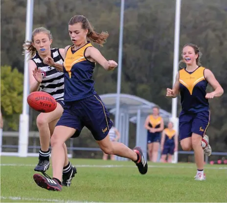  ?? Photo: Fairholme College ?? FINALS TIME: Fairholme’s Evie Mason (left) punts the ball downfield with teammate Zoe Crooke in support. Fairholme will face Mountain Creek State High School in the semi-final of the AFLQ Schools Cup next week.