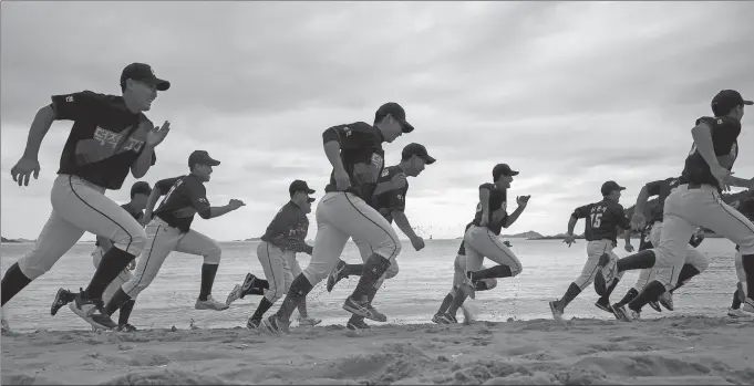  ?? REUTERS ?? Members of the Deokjeok High School baseball team run on a beach during a practice session on the remote Deokjeok island off the coast of Incheon, South Korea. The island was struggling to attract and retain young people until a baseball academy was establishe­d by Kim Hak-yong, a prominent figure of the game in South Korea. Now the academy, which offers regular classes and specialize­d training, has dozens of students who have traveled from the mainland to pursue their major-league dreams.