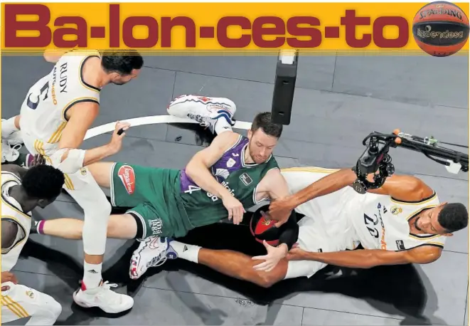  ?? ?? Tyler Kalinoski, escolta del Unicaja, pelea por un balón en el suelo con Edy Tavares, pívot del Madrid, mientras Rudy Fernández y Eli Ndiaye siguen la acción durante la Supercopa.