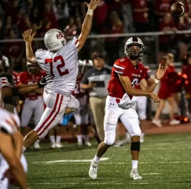  ?? Michael M. Santiago/Post-Gazette ?? Nicolas Pederson, defensive lineman for North Hills, left, leaps to pressure Peters Township quarterbac­k Logan Pfeuffer.