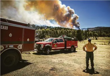  ?? Jim Weber / Associated Press ?? A firefighte­r watches a blaze in northern New Mexico as about 2,000 battle the largest U.S. wildfire.