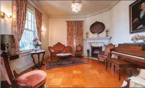  ??  ?? The parlor features an elegant fireplace and an oak parquet floor with cherry trimwork.