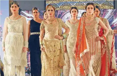  ?? — AFP photos ?? Models present creations by Pakistani fashion designers during a fashion show in Peshawar on December.