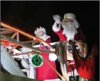  ??  ?? Santa and Mrs. Claus wave at the crowds of children lining Lodi streets.