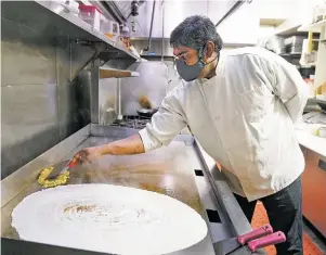  ??  ?? Chef Karuppasam­y makes a paper dosa with masala on the side at Paper Dosa.