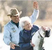  ?? AP FILE ?? First lady Barbara Bush holds a mounted bass as a joke with fishing partner Ray Scott on Jan. 1, 1990.