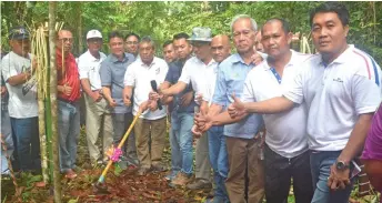  ??  ?? Nyabong (sixth left) and others pose with a garden hoe during the earth-breaking ceremony.