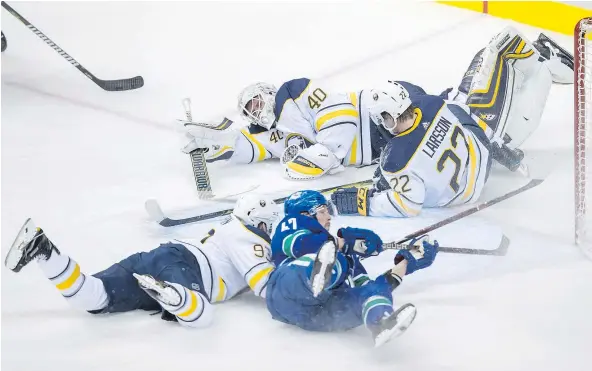  ?? — THE CANADIAN PRESS ?? Sabres centre Johan Larsson crashes into goalie Robin Lehner as Buffalo defenceman Victor Antipin and Canucks winger Sven Baertschi join the pileup in the blue paint Thursday at Rogers Arena. Lehner finished the game, posting 30 saves in a 4-0 shutout.