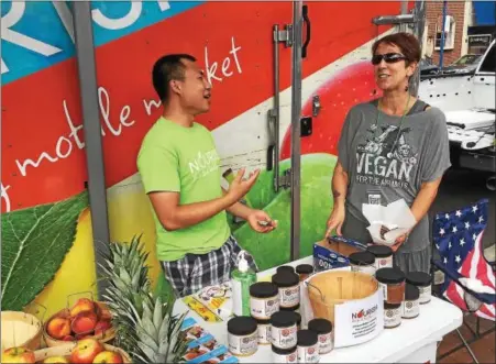  ?? VIRGINIA LINDAK — FOR DIGITAL FIRST MEDIA ?? Zoe Sakos, right, with the Nourish Mobile and the organizer for the Phoenixvil­le Veg Fest, chatswith one of the vendors.