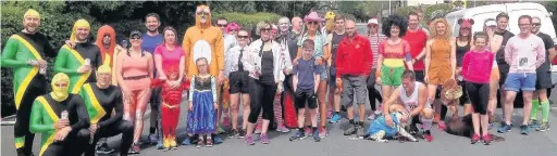  ??  ?? The crowd in fancy dress who ran the 7km in memory of Mike Garnett and, below, his son Martin with wife Jane RojasTrega­rtha and handing over the £500 donation at the lifeboat station