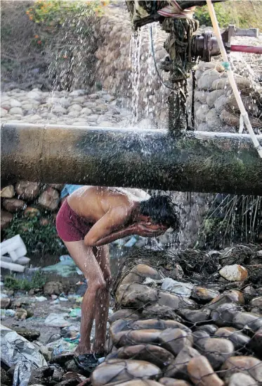  ?? Channi Anand/ the associated press ?? A man near Jammu, India, bathes under a leaking water-supply pipeline on World Water Day Friday
