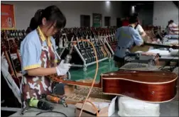  ?? ZHAO YANDI / FOR CHINA DAILY ?? Workers assemble guitars at Zheng’an’s internatio­nal guitar industrial park.