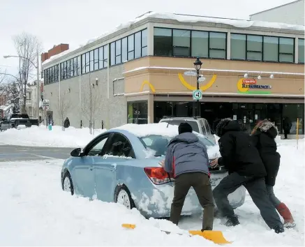  ??  ?? Une voiture est restée enlisée pendant plus de 20 minutes, malgré l’aide de bons samaritain­s, en plein milieu de la rue Gordon, l’une des moins bien déblayées de l’arrondisse­ment Verdun.