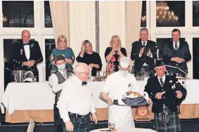  ?? ?? Tae a haggis Guests applaud as the haggis is piped in in front of the top table