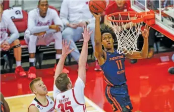  ?? AP ?? Illinois guard Ayo Dosunmu shoots against Wisconsin’s Nate Reuvers during the first half Wednesday night in Madison, Wis. Dosunmu scored a team-high 18 points, including a three-pointer with 46 seconds left.